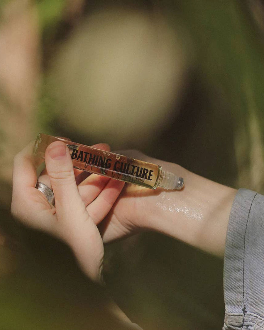 model rolling 0.3 oz roller perfume oil in cathedral grove scent on her wrist