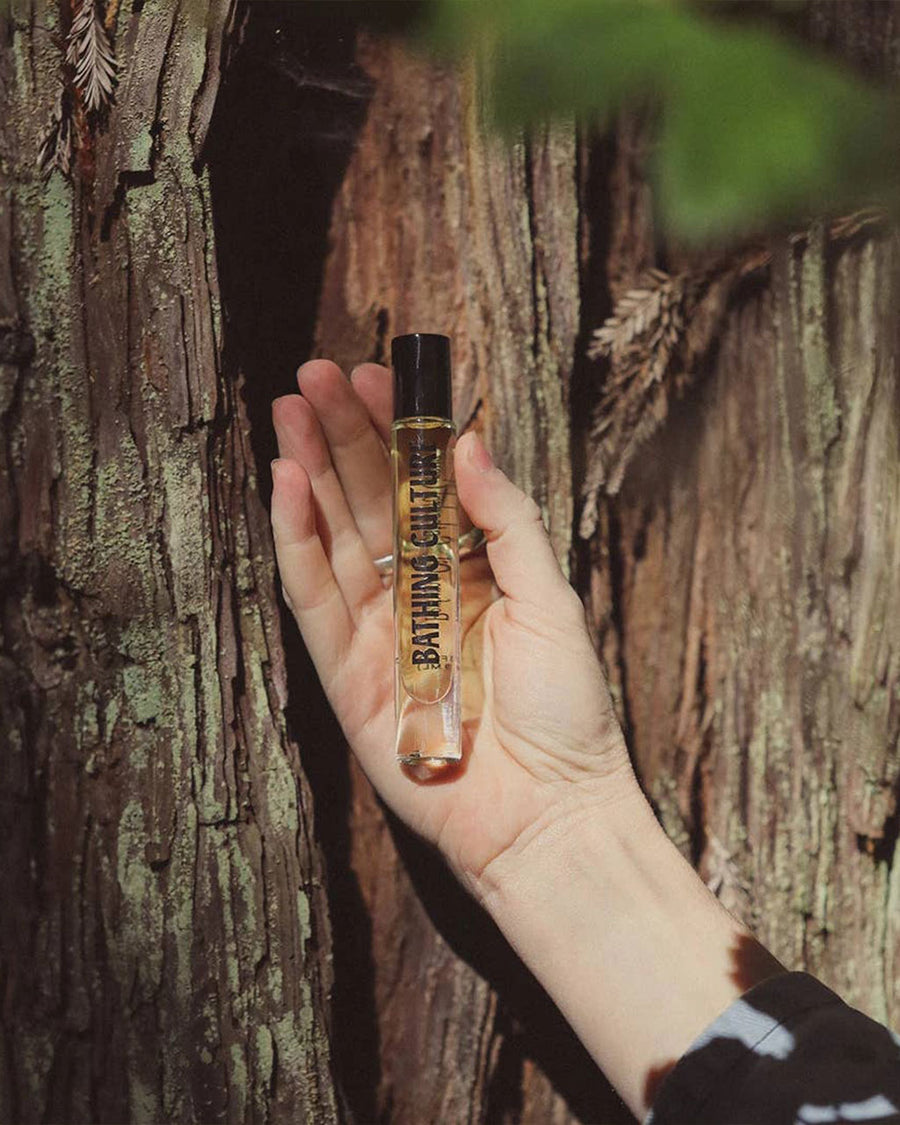 model holding 0.3 oz roller perfume oil in cathedral grove scent