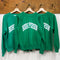 kelly green sweatshirts with white 'BOOK PERSON' across the front hanging on hangers