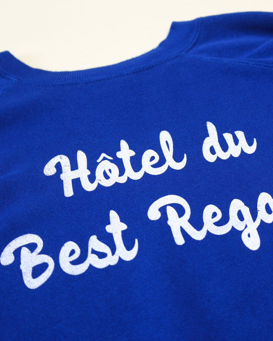 up close of royal blue sweatshirt with white 'Hotel du Best Regards' across the front
