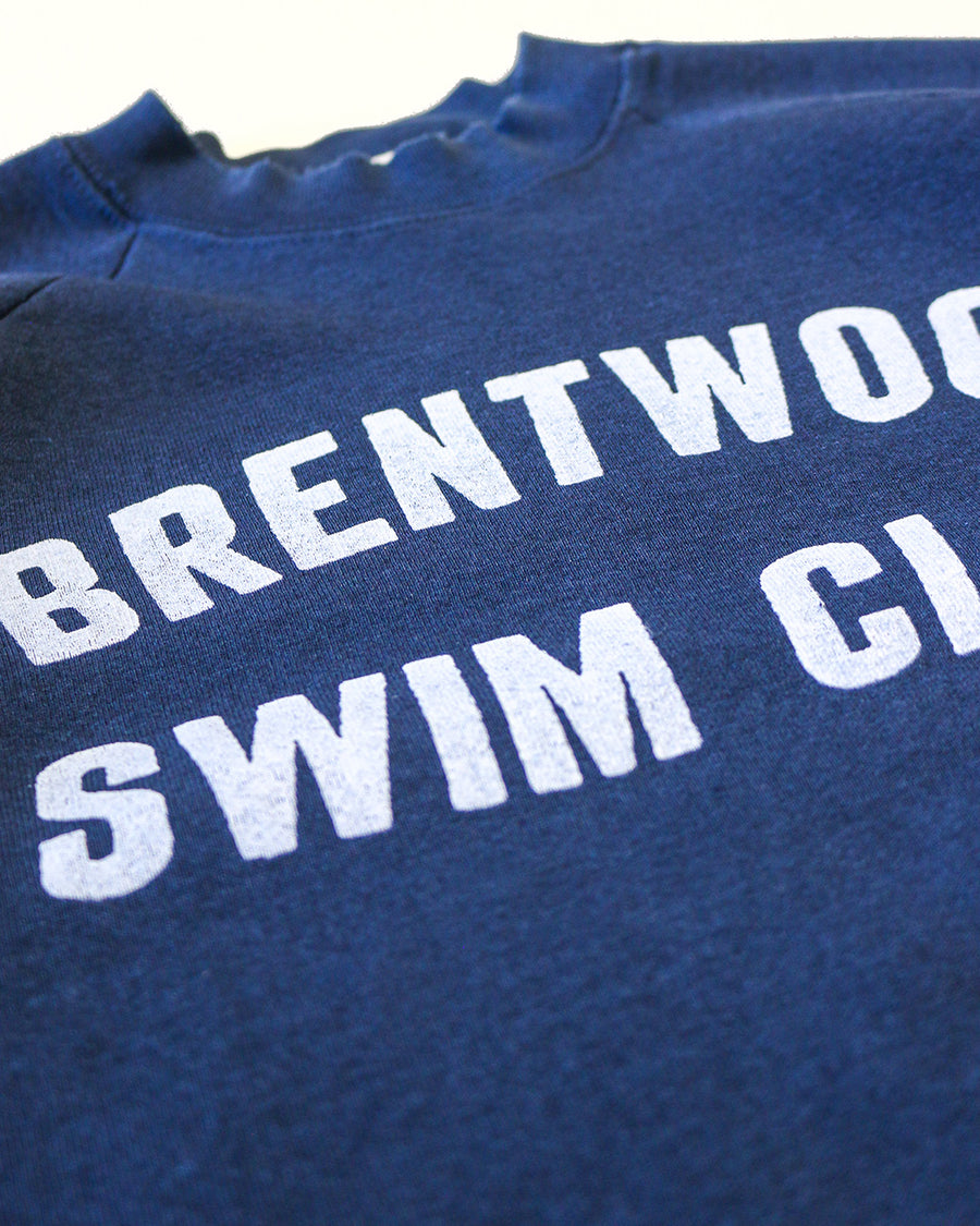 side view of navy sweatshirt with white 'BRENTWOOD SWIM CLUB' across the front