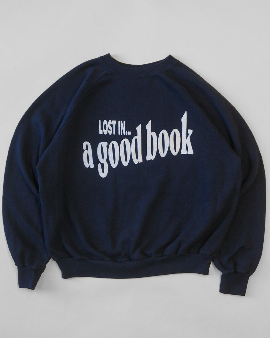 navy sweatshirt with white 'LOST IN... GOOD BOOK' across the front