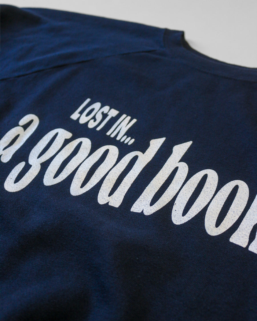 up close of navy sweatshirt with white 'LOST IN... GOOD BOOK' across the front