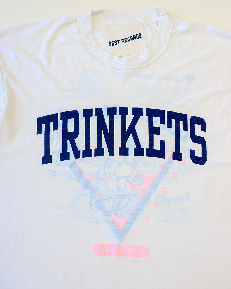 up close of vintage white tee with navy TRINKETS across the front