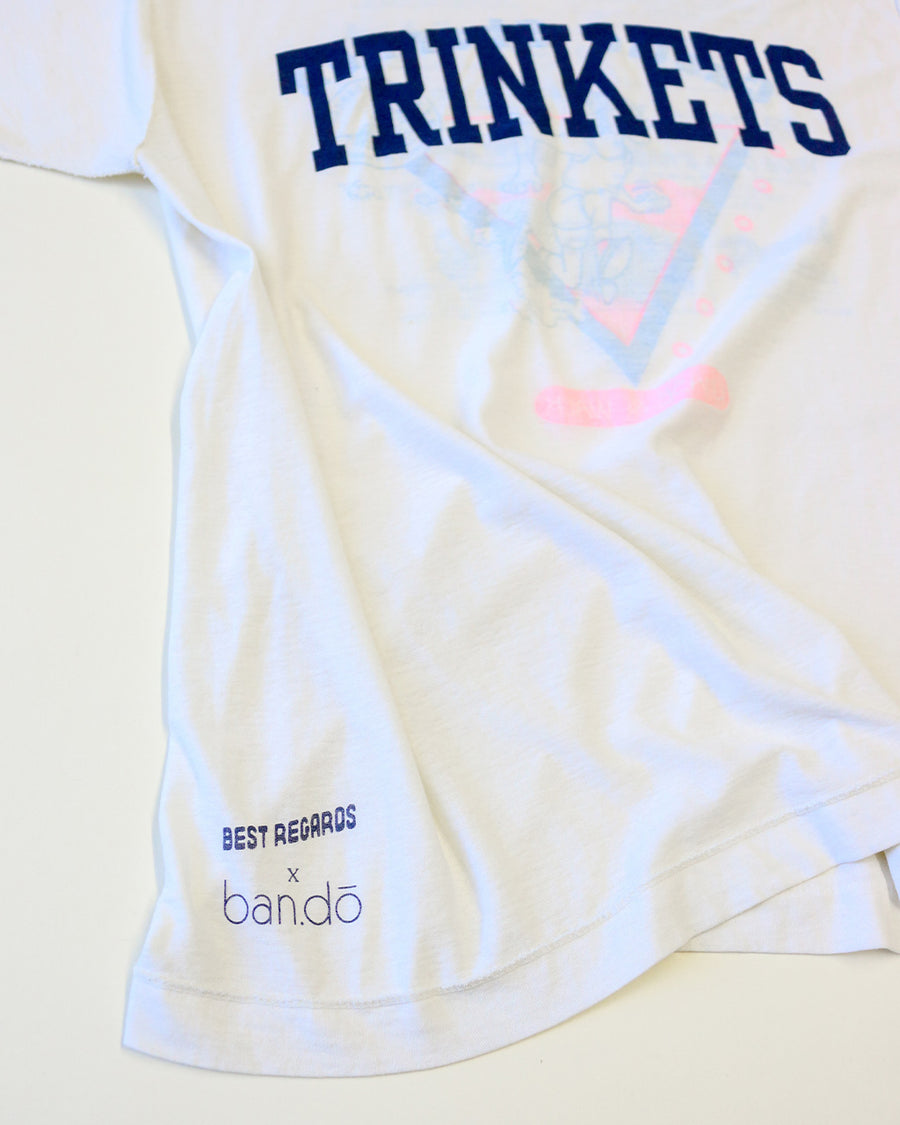 side view of vintage white tee with navy TRINKETS across the front