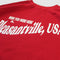 up close of red sweatshirt with white 'WISH YOU WERE HERE IN...PLEASANTVILLE, USA' across the front