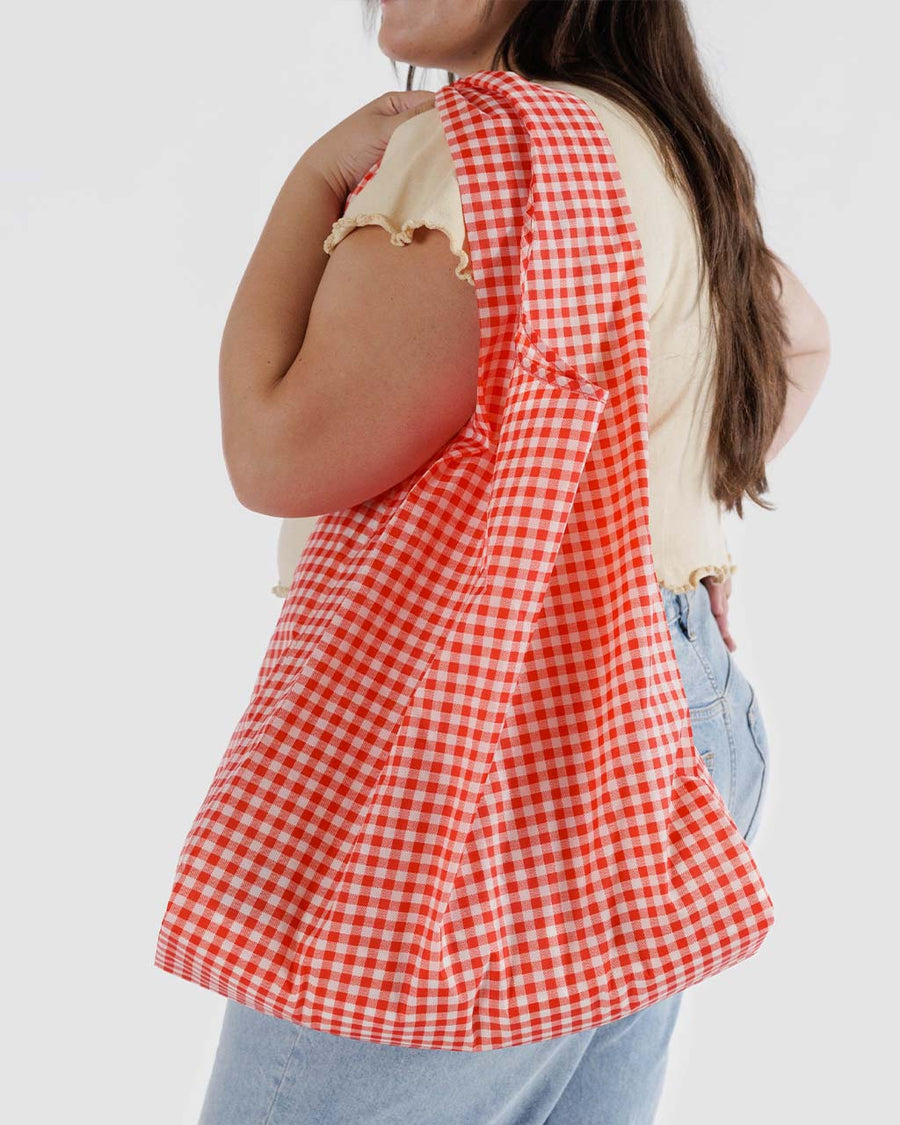 model wearing red and white gingham big baggu over their shoulder