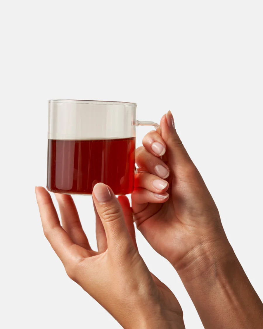 model holding brewed cup of chai tea