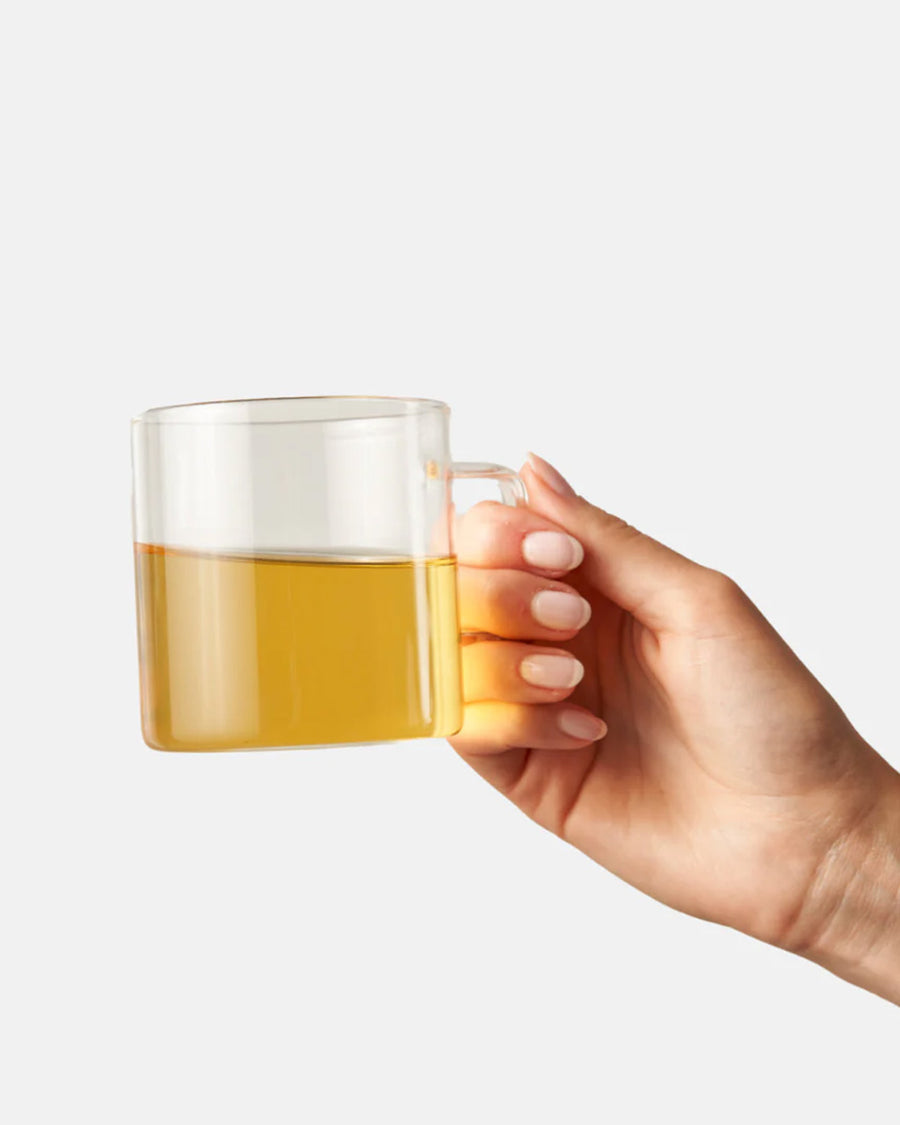 model holding cup of chamomile mint tea