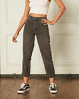 model wearing black high waist jeans with cuffed bottoms