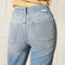 up close of back of model wearing light denim jeans with raw hem and distressing throughout