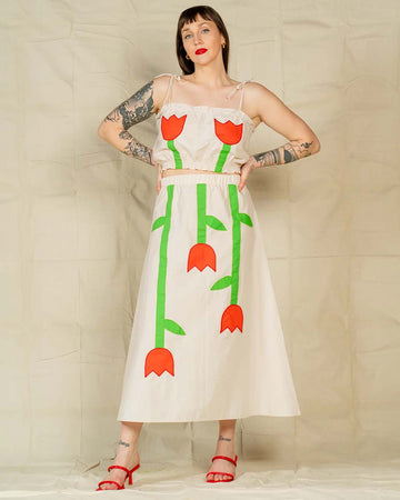 model wearing cream maxi skirt with abstract red tulip print and matching top