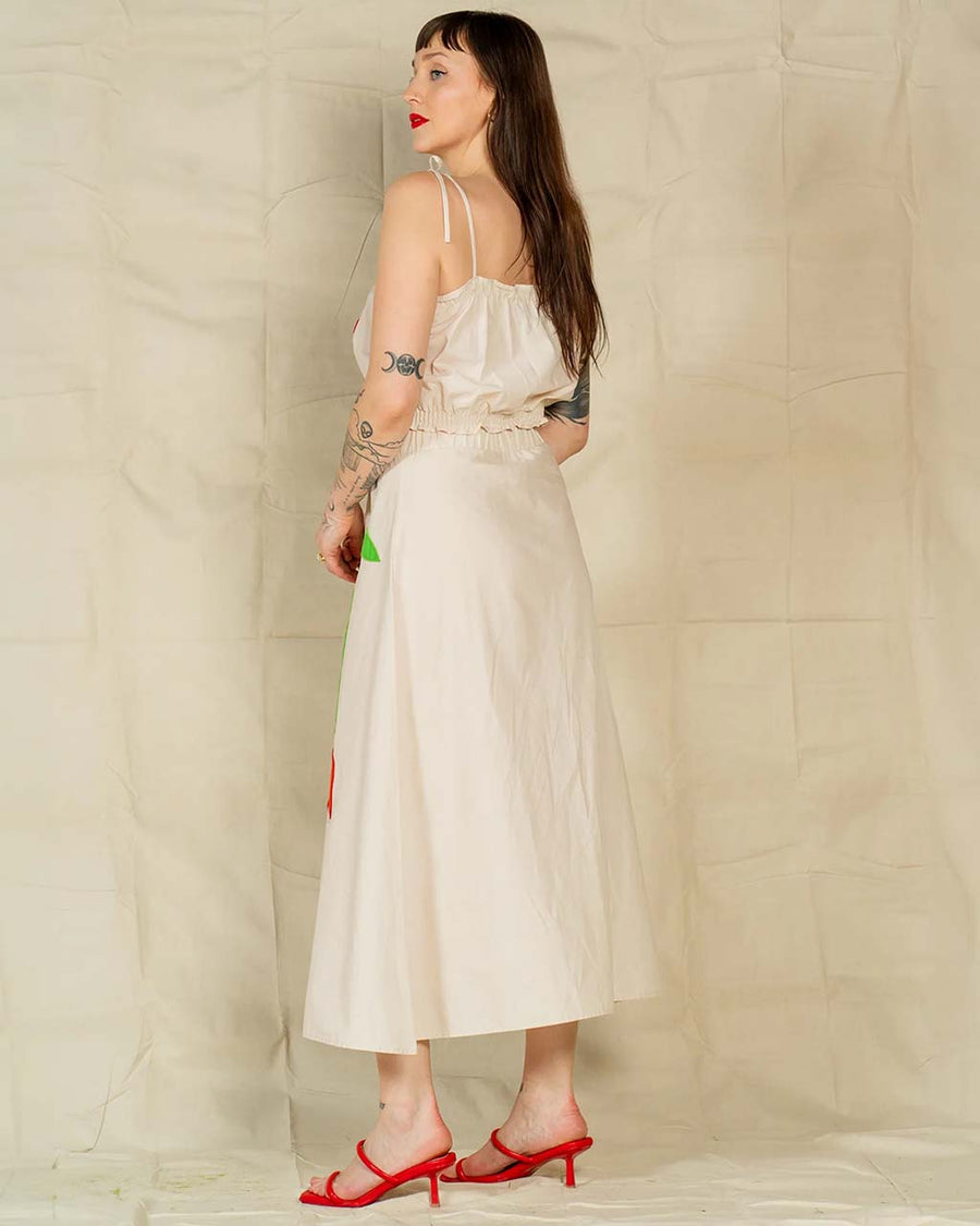 back view of model wearing cream maxi skirt with abstract red tulip print and matching top