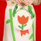 model holding cream round purse with red tulip and green beaded leaves on the strap