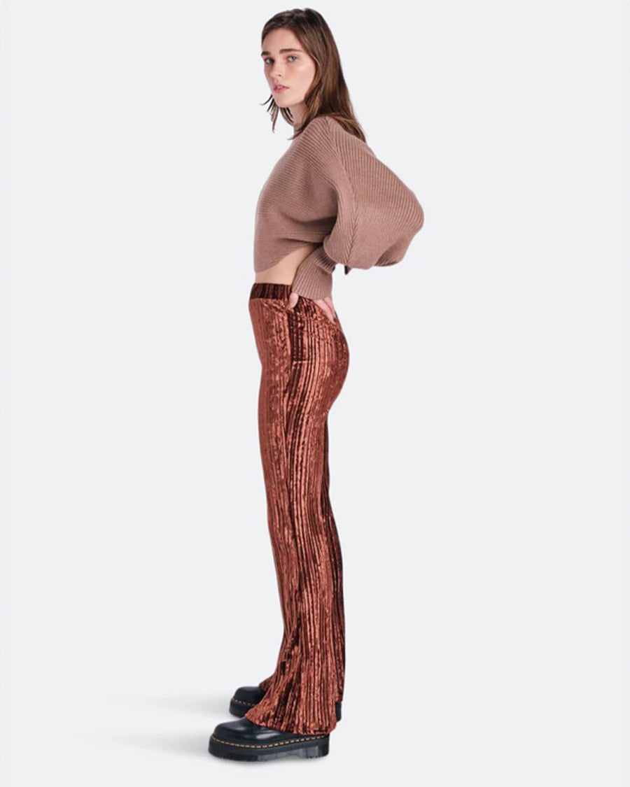 sideview of model wearing brown crushed velvet flared pants