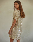 back view of model wearing gold sequin midi dress with short sleeves