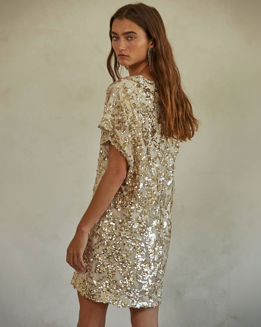 back view of model wearing gold sequin midi dress with short sleeves