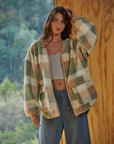 model wearing brown and green plaid jacket with zipper front and patch pockets