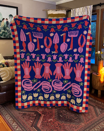 blue throw blanket with checkered border and various gardening tools