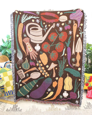 brown throw blanket with colorful veggie and gardening tools with fringe around the edges