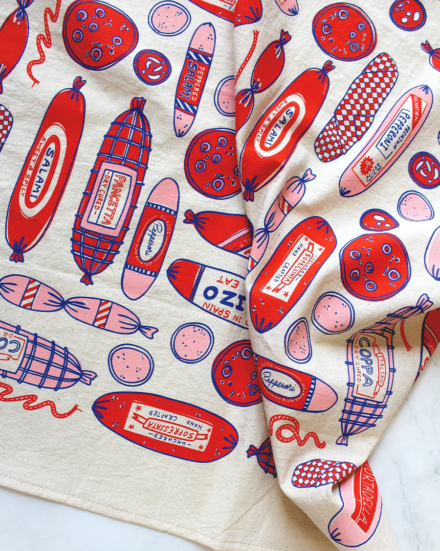 up close of cream tea towel with red/pink pepperoni print
