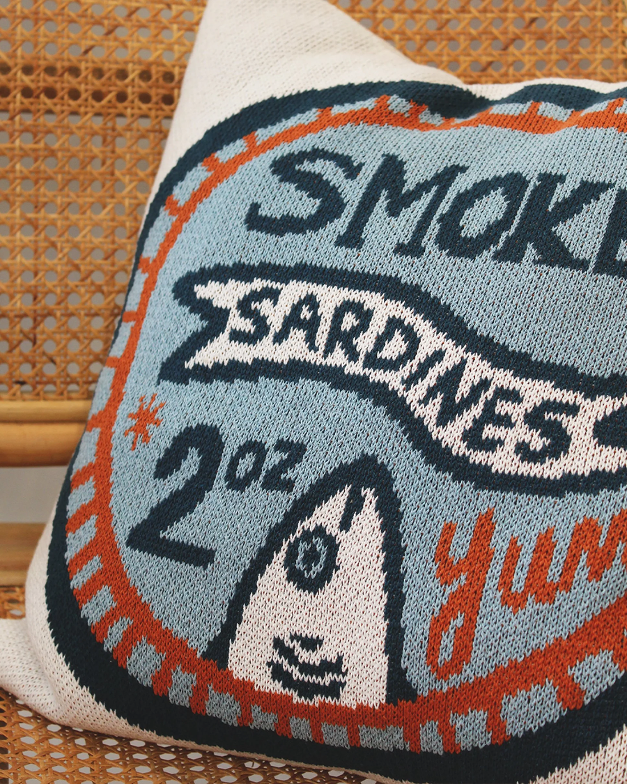 up close of blue and orange 'smoked sardines' can throw pillow