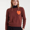 model wearing brown sweater with textured orange heart on the left bust