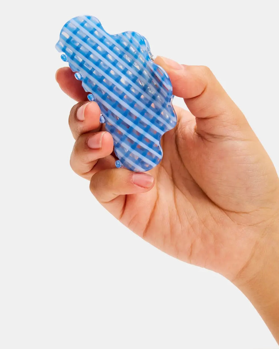 model holding clear and blue plaid squiggle hair claw