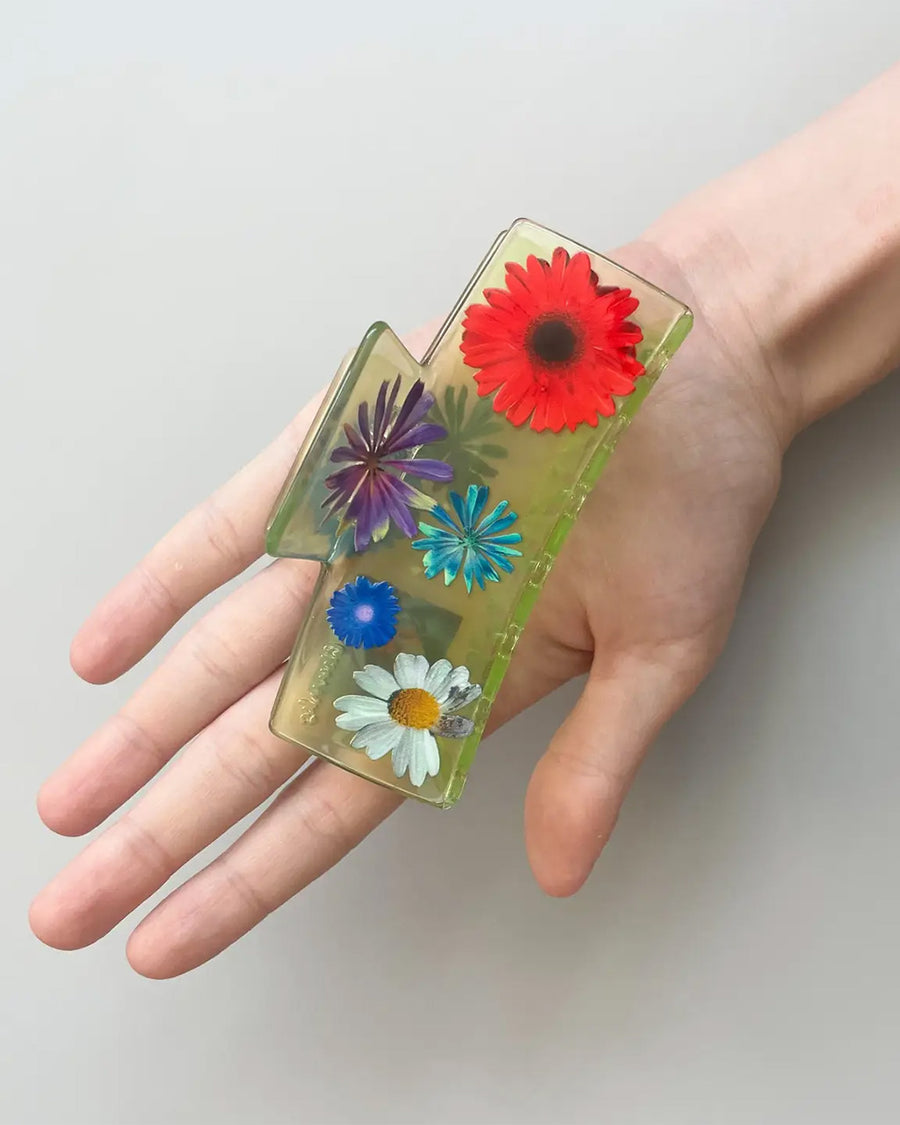 model holding clear box hair claw with realistic flower print