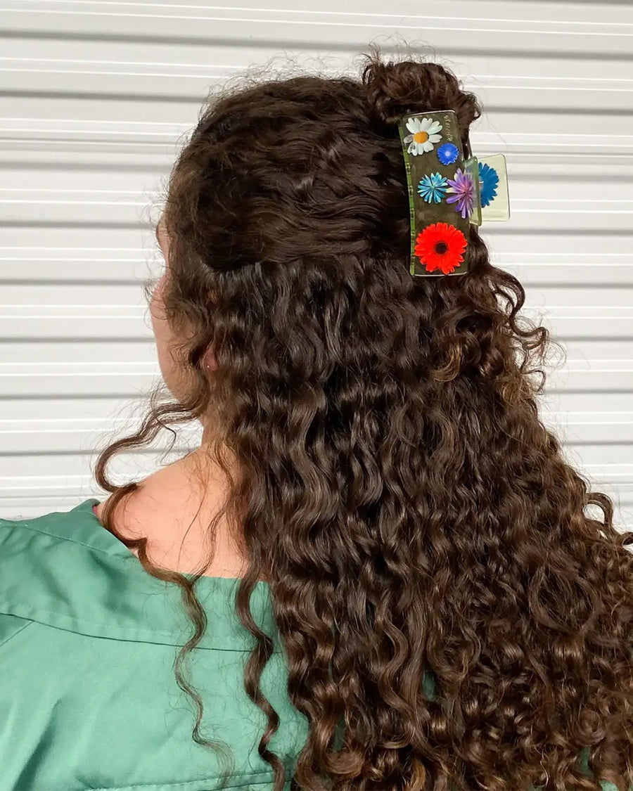 model wearing clear box hair claw with realistic flower print