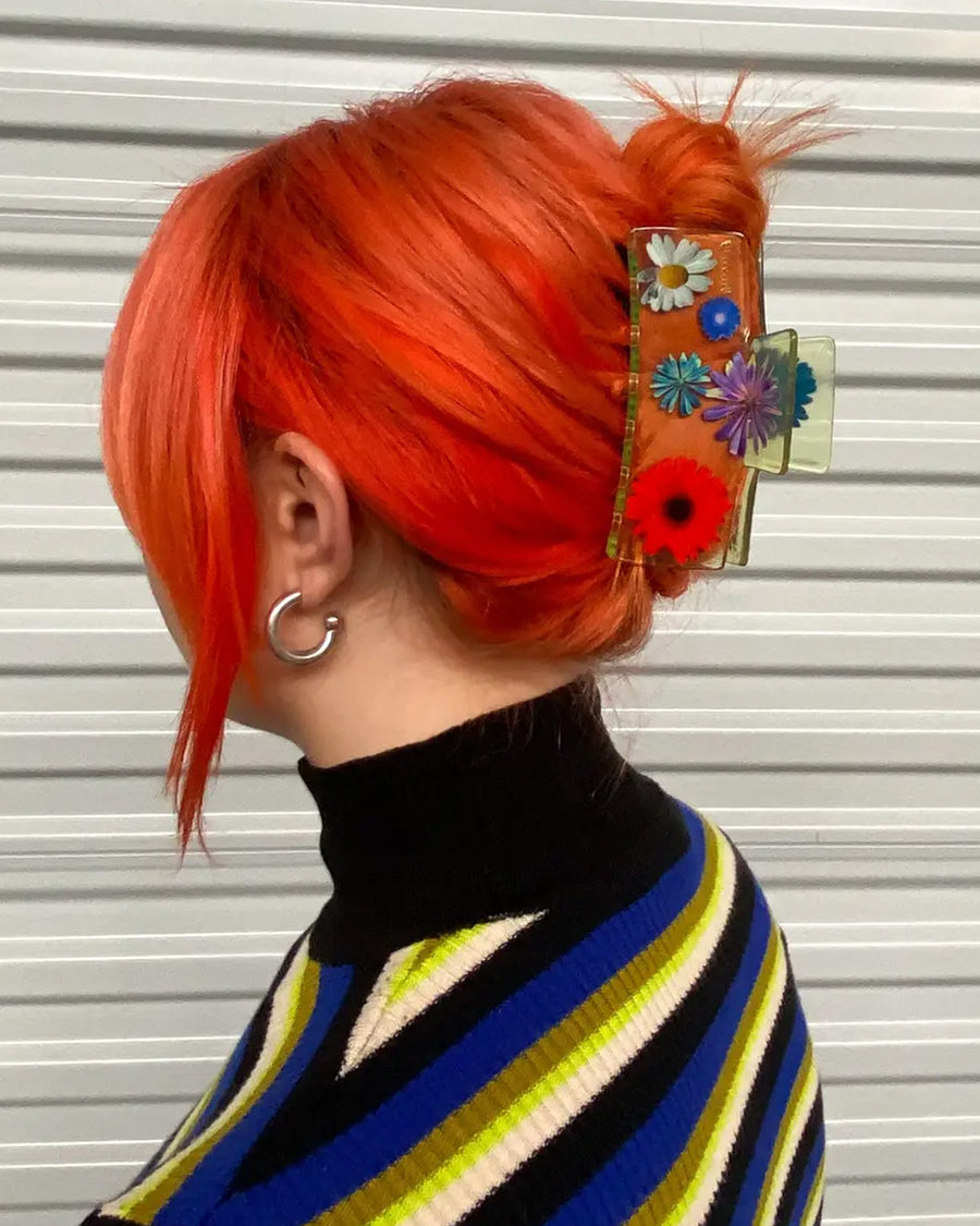 model wearing clear box hair claw with realistic flower print