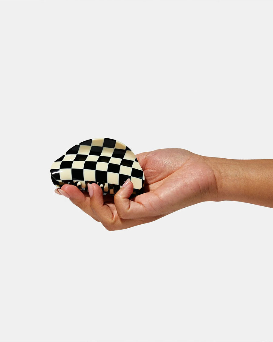 model holding black and off white checkered hair clip