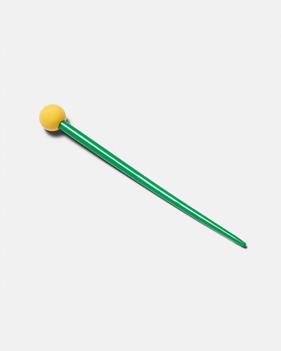green hair stick with yellow ball on the end