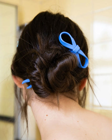 model wearing blue large bow hairpin