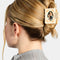 model wearing cream claw clip with peach dainty flowers and photo inside