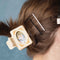 model wearing model wearing cream claw clip with peach dainty flowers and kitty photo inside