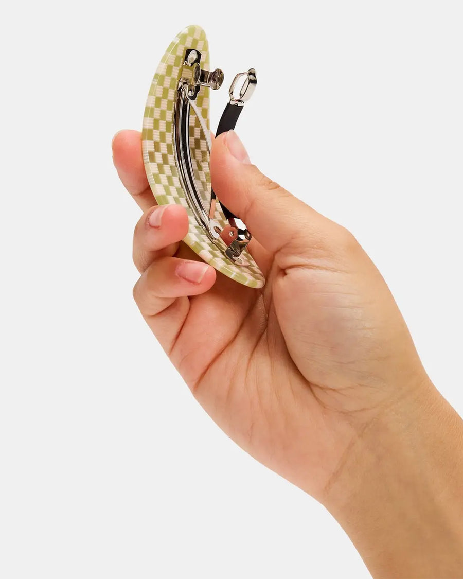 model holding green and white checkered oval barrette