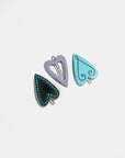 set of three heart hair clips: black heart with blue rhinestones, lavender heart with hollow center and blue heart with squiggle design