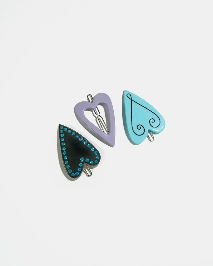 set of three heart hair clips: black heart with blue rhinestones, lavender heart with hollow center and blue heart with squiggle design