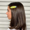 model wearing blue and yellow swirl oval hair clip