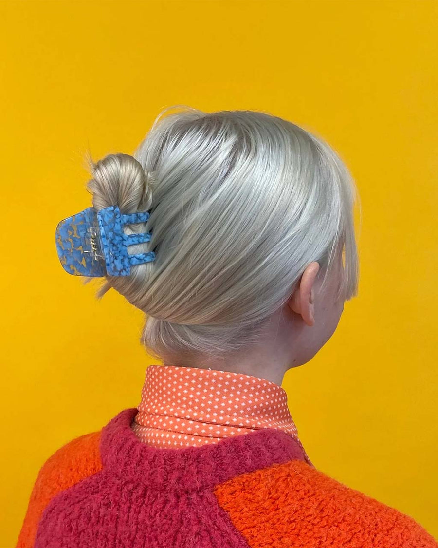 model wearing blue floral hair claw