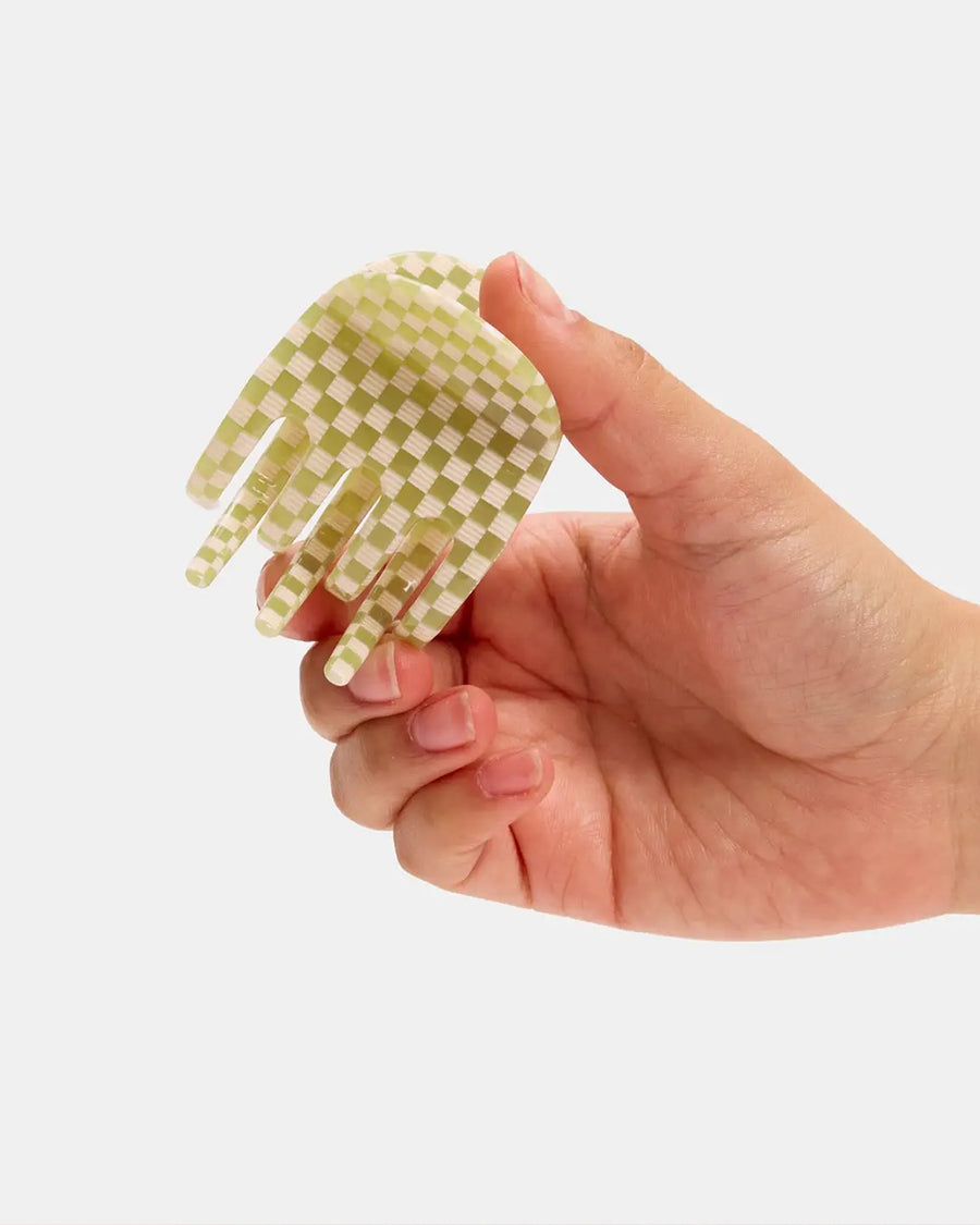 model holding green and white checkered hair claw