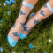 model wearing sheer socks with blue butterflies and blue trim
