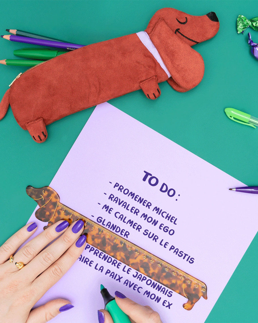 model using tortoise shell dachshund shaped ruler to write a to do list