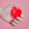 model holding red heart shaped hair claw