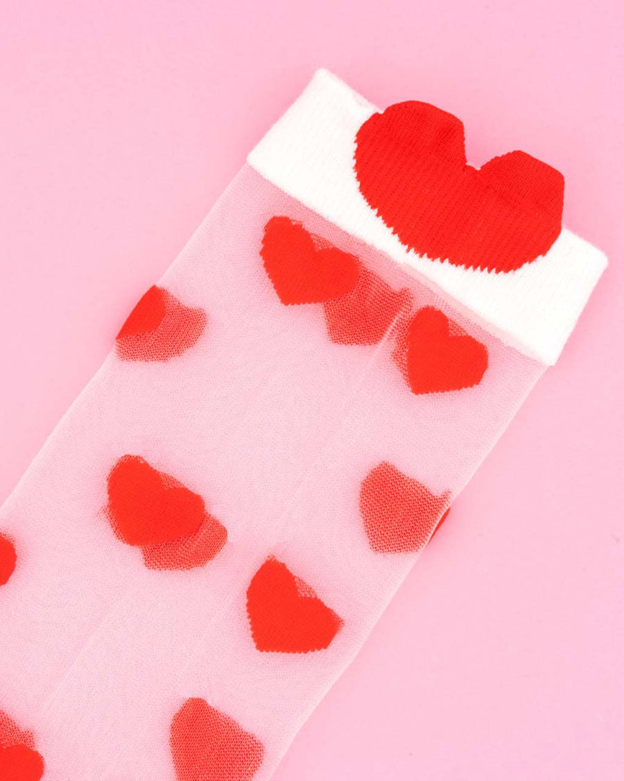 up close of of sheer socks with red heart print and white trim