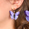 model wearing purple butterfly earrings with gold hoops