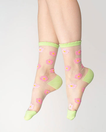 model wearing sheer socks with dark and light pink all over flower design with lime green trim