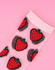 up close of sheer socks with all over strawberry print and pink trim