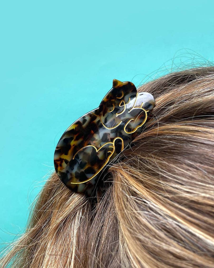 model wearing tortoiseshell cat hair claw with gold accents